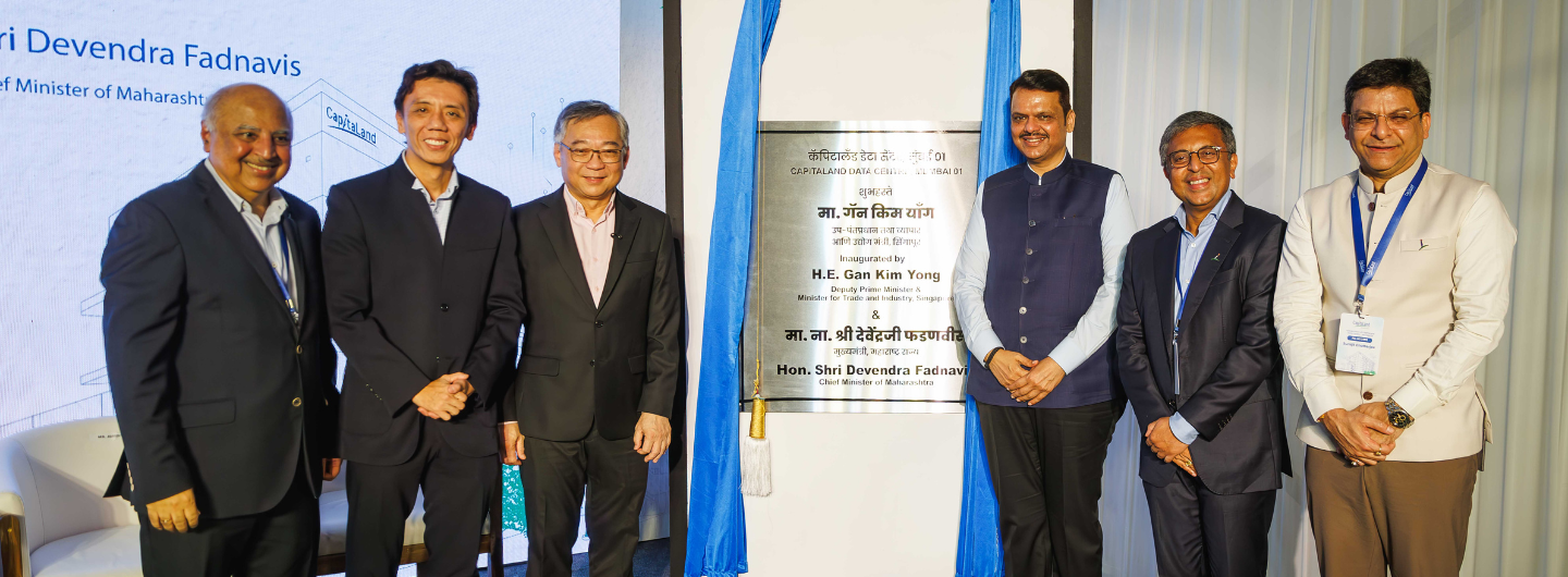 Six men in formal attire pose by a plaque at CapitaLand Data Centre's Mumbai inauguration.
